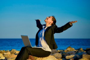 attractive business woman working on laptop at beach