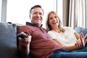 Shot of a mature couple watching tv in their living room